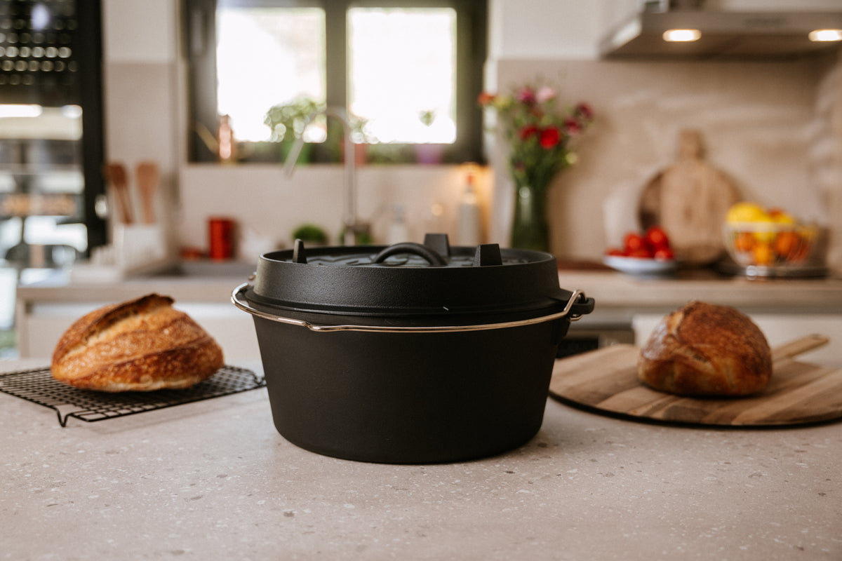 Echter AMZBBQ Dutch Oven zwischen zwei frisch gebackenen Broten in einer hellen Küche