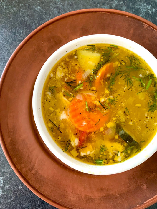 Stockfoto: klare Gemüsesuppe mit Kartoffelstücken, Karotten und Kräutern. Foto: Helen Brudna / Pexels.