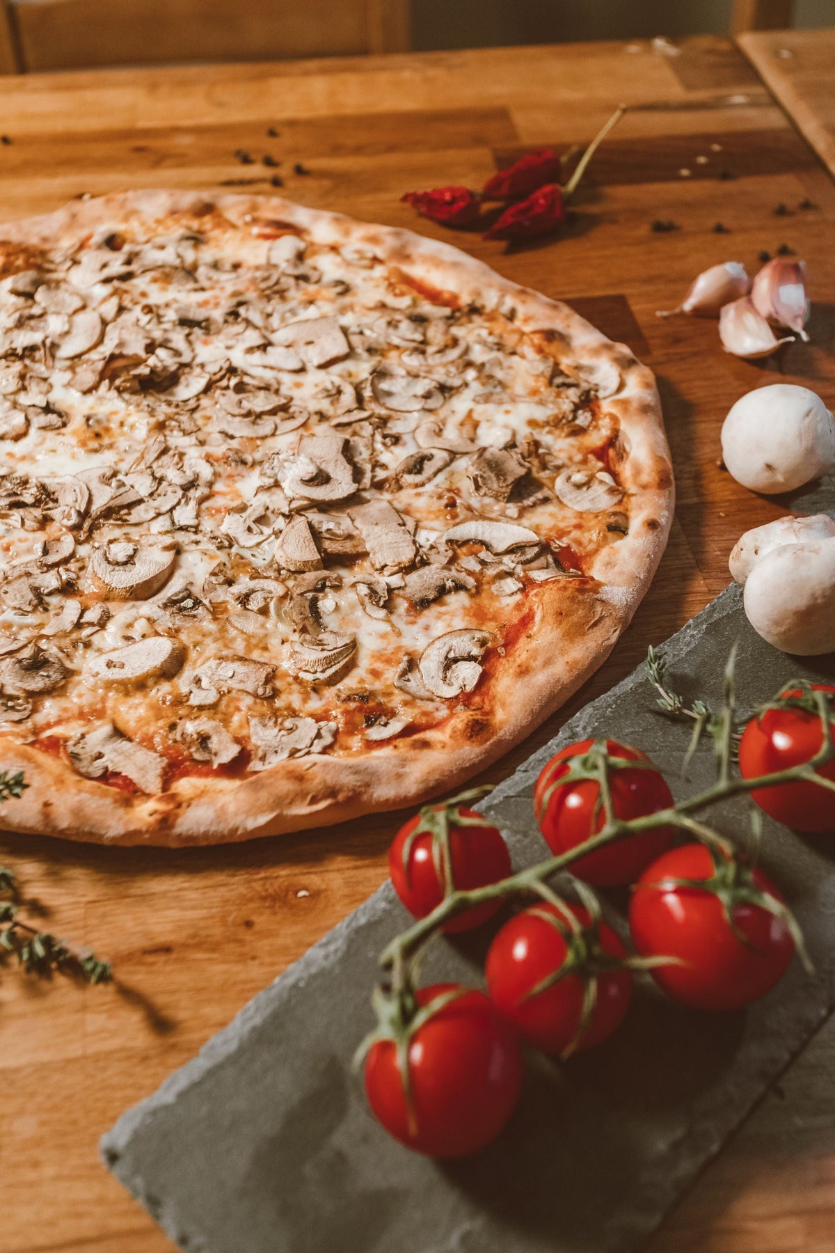 Stockfoto: Pilzpizza mit Champignons, Tomatensauce und Käse auf einem Holzbrett. Foto: ROMAN ODINTSOV / Pexels.