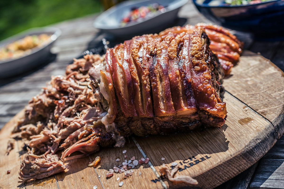 Servieridee: Gebratenes Schweinefleisch mit Kruste und bereits gezupften Fleischfasern auf einem Holzbrett. Foto: Jez Timms / Unsplash.