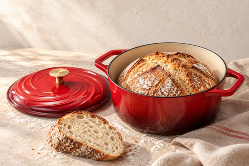 Produktvisualisierung aus dem AMZBBQ Booklet: roter emaillierter Brotbacktopf mit Brot und abgelegtem Deckel