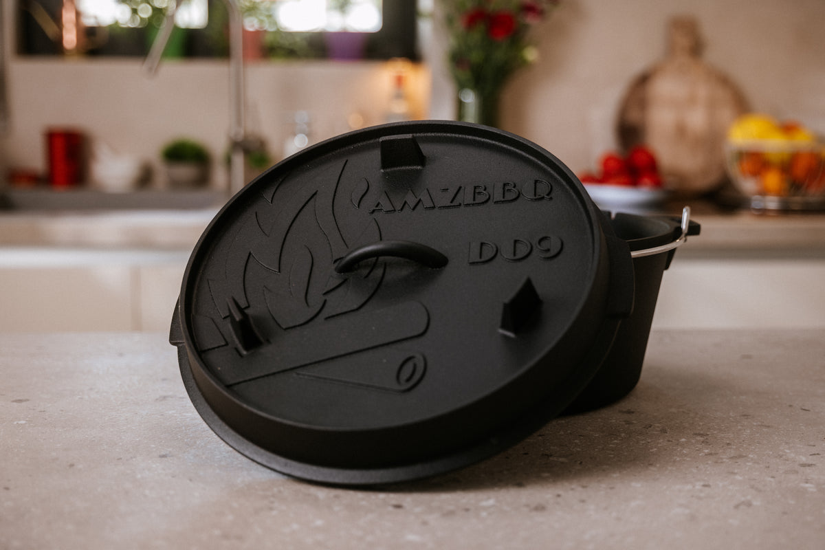 AMZBBQ DO9 Dutch Oven mit angelehntem Deckel auf einer hellen Küchenarbeitsplatte