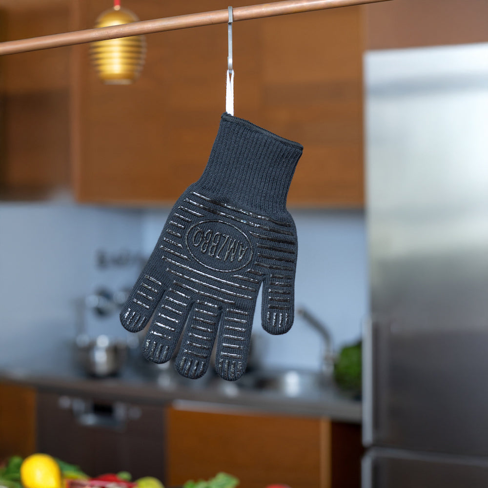 Schwarzer AMZBBQ Grillhandschuh hängt an einer Stange in einer Küche